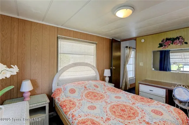 a bedroom with a bed and a large mirror in it