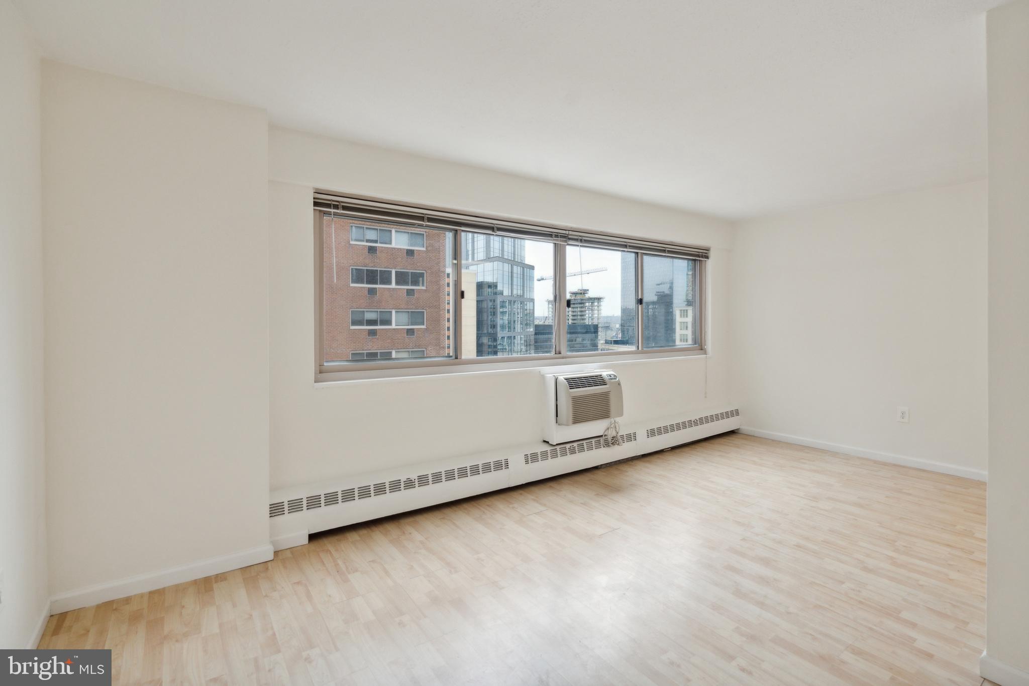2101 Chestnut Street, Unit 1102 Philadelphia, PA 19103 - Photo 2 of 17 an empty room with wooden floor and windows