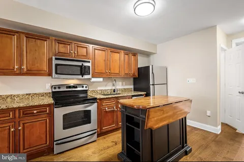 a kitchen with stainless steel appliances granite countertop a stove microwave and sink