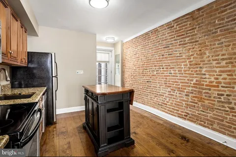 a kitchen with stainless steel appliances wooden cabinets and a stove top oven
