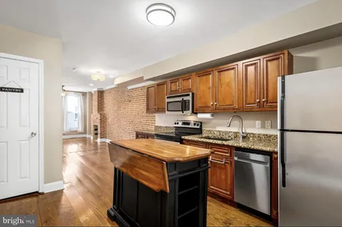 a kitchen with a refrigerator stove microwave and sink