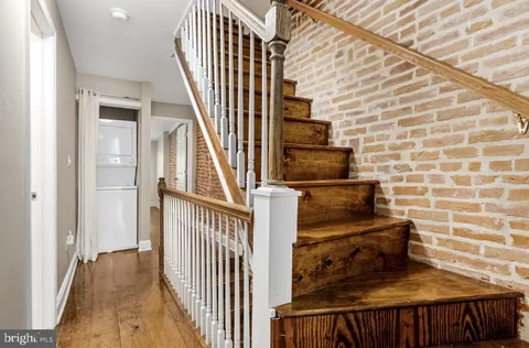 a view of a hallway with wooden floor and staircase