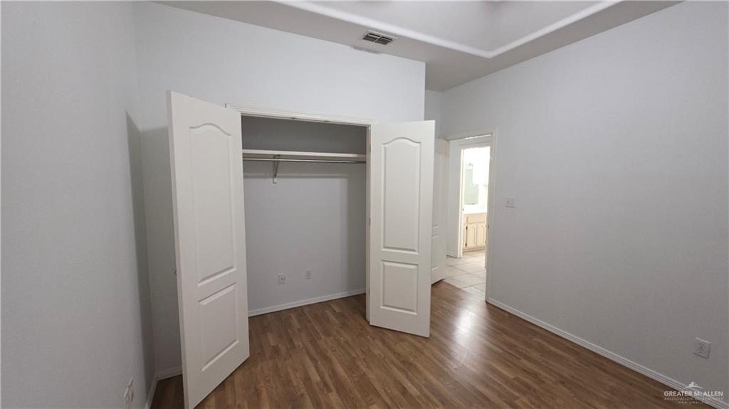 2014 Northgate Circle Weslaco, TX 78599 - Photo 12 of 23 Unfurnished bedroom featuring dark wood-style flooring and a closet