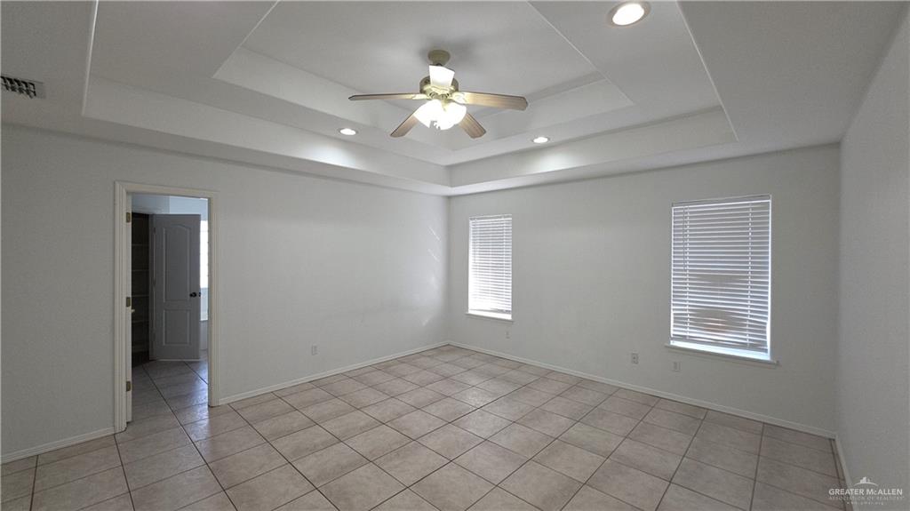 2014 Northgate Circle Weslaco, TX 78599 - Photo 14 of 23 Spare room with a tray ceiling, a ceiling fan, light tile patterned floors, and recessed lighting