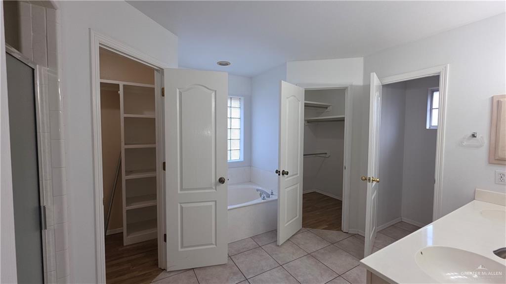 2014 Northgate Circle Weslaco, TX 78599 - Photo 16 of 23 Full bath with a walk in closet, a bath, light tile patterned floors, and double vanity
