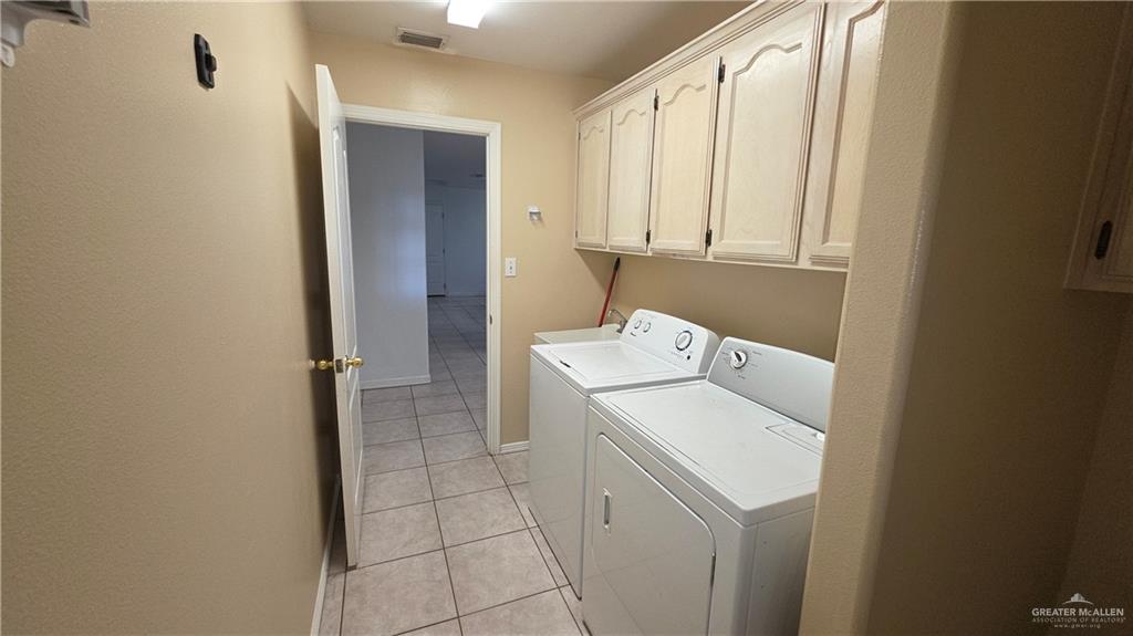 2014 Northgate Circle Weslaco, TX 78599 - Photo 21 of 23 Laundry room with light tile patterned floors, cabinet space, and washing machine and dryer
