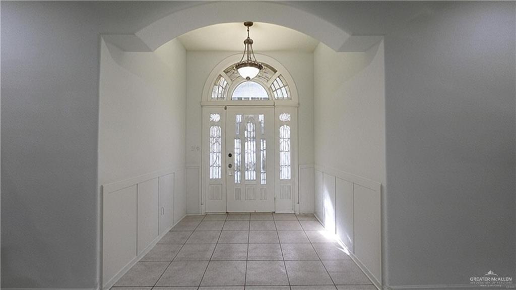 2014 Northgate Circle Weslaco, TX 78599 - Photo 3 of 23 Foyer with light tile patterned floors, a decorative wall, a wainscoted wall, and arched walkways