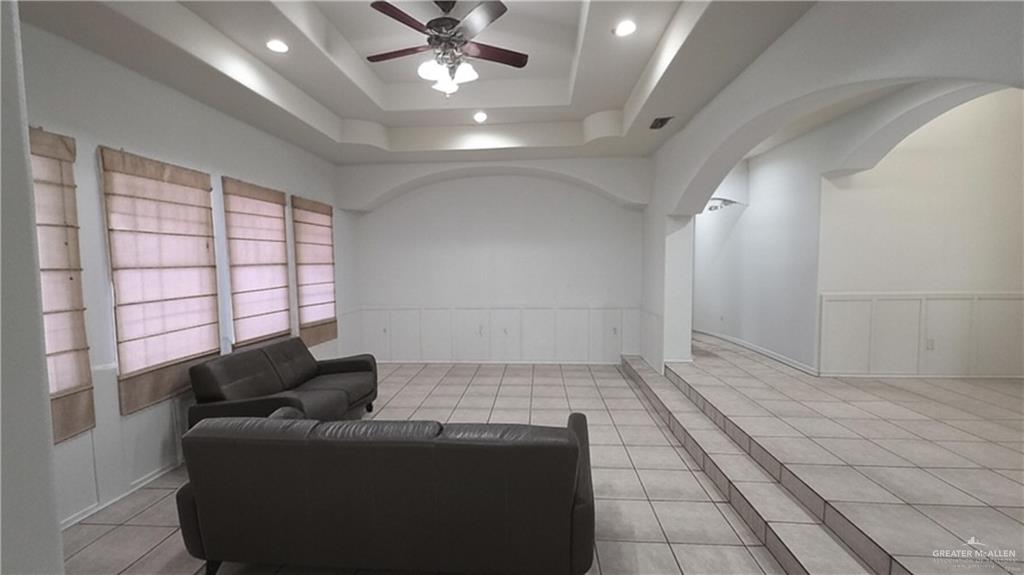 2014 Northgate Circle Weslaco, TX 78599 - Photo 5 of 23 Living room with light tile patterned floors, wainscoting, a ceiling fan, a raised ceiling, and recessed lighting
