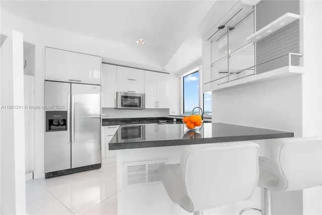 a kitchen with stainless steel appliances a refrigerator sink and microwave