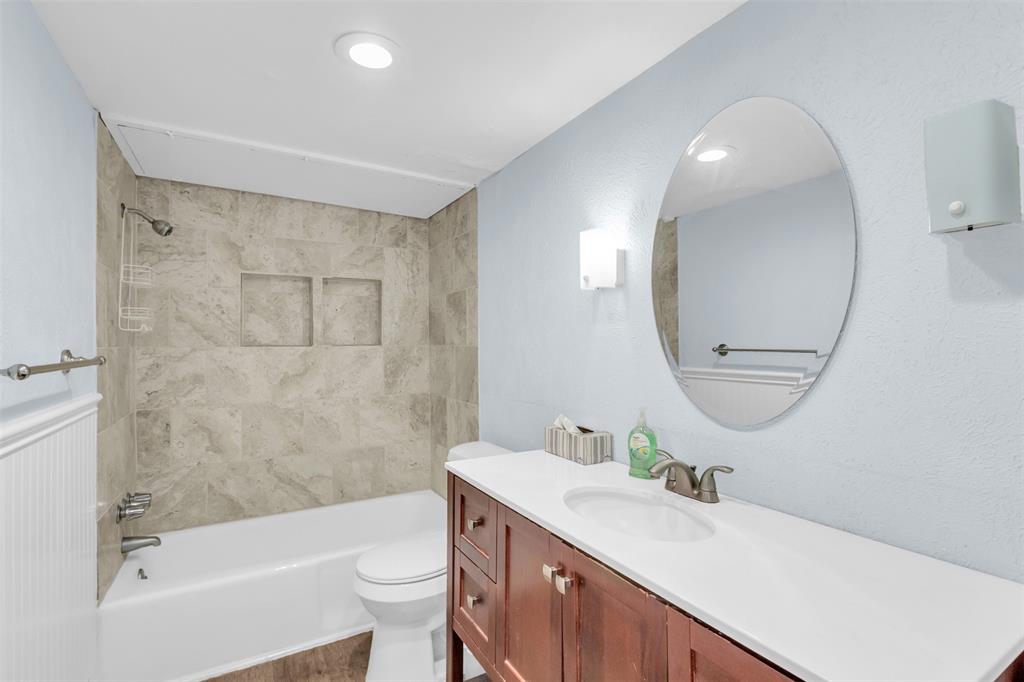 4688 Matilda Street, Unit H Dallas, TX 75206 - Photo 18 of 20 a bathroom with a sink a toilet and a mirror