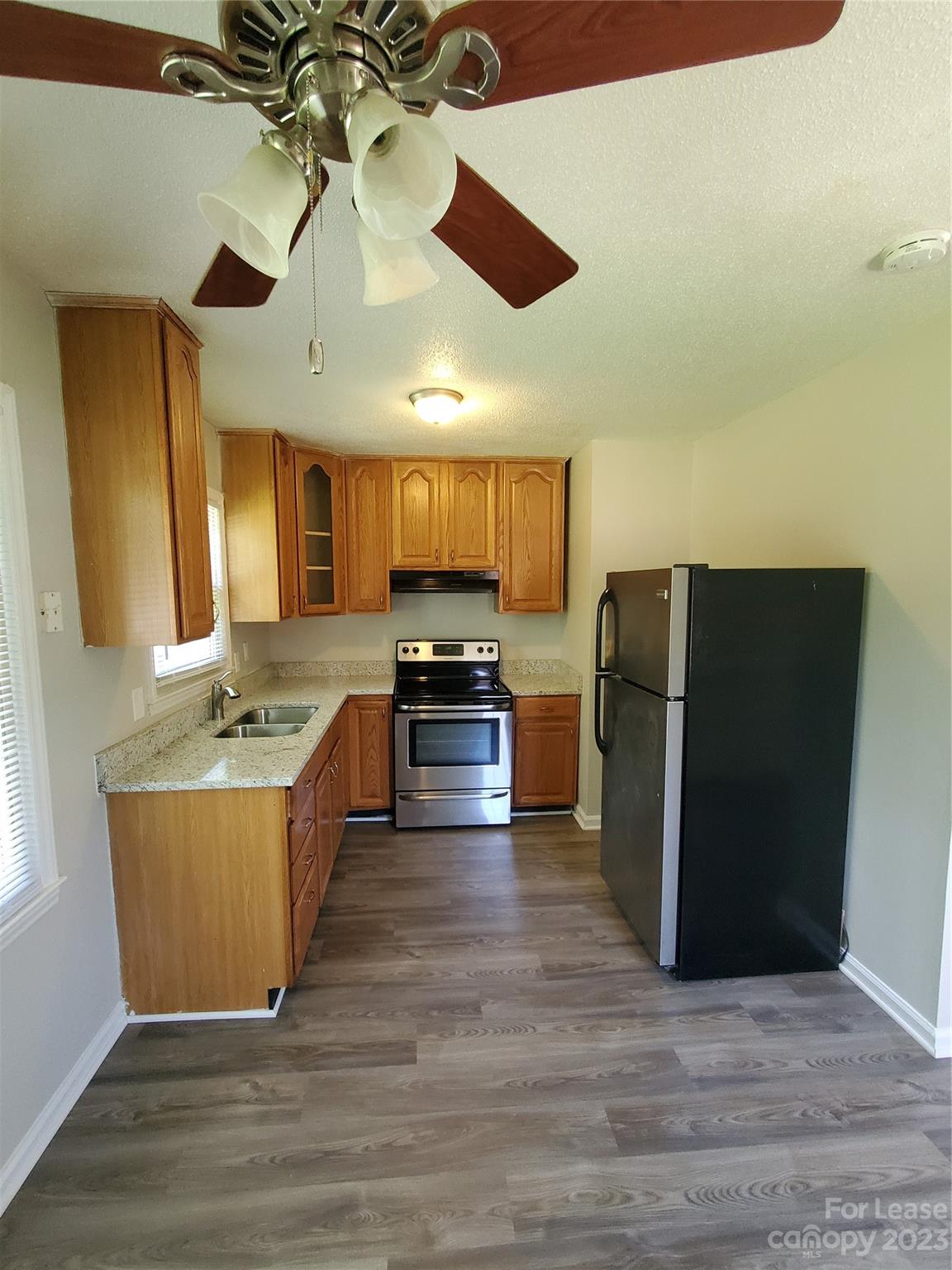 216 Lakeside Avenue Davidson, NC 28036 - Photo 2 of 6 a large kitchen with stainless steel appliances wooden floor and chandelier
