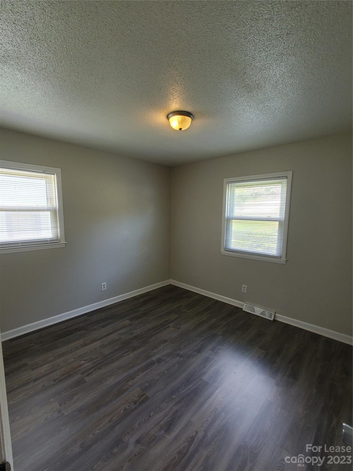 216 Lakeside Avenue Davidson, NC 28036 - Photo 4 of 6 an empty room with wooden floor and windows