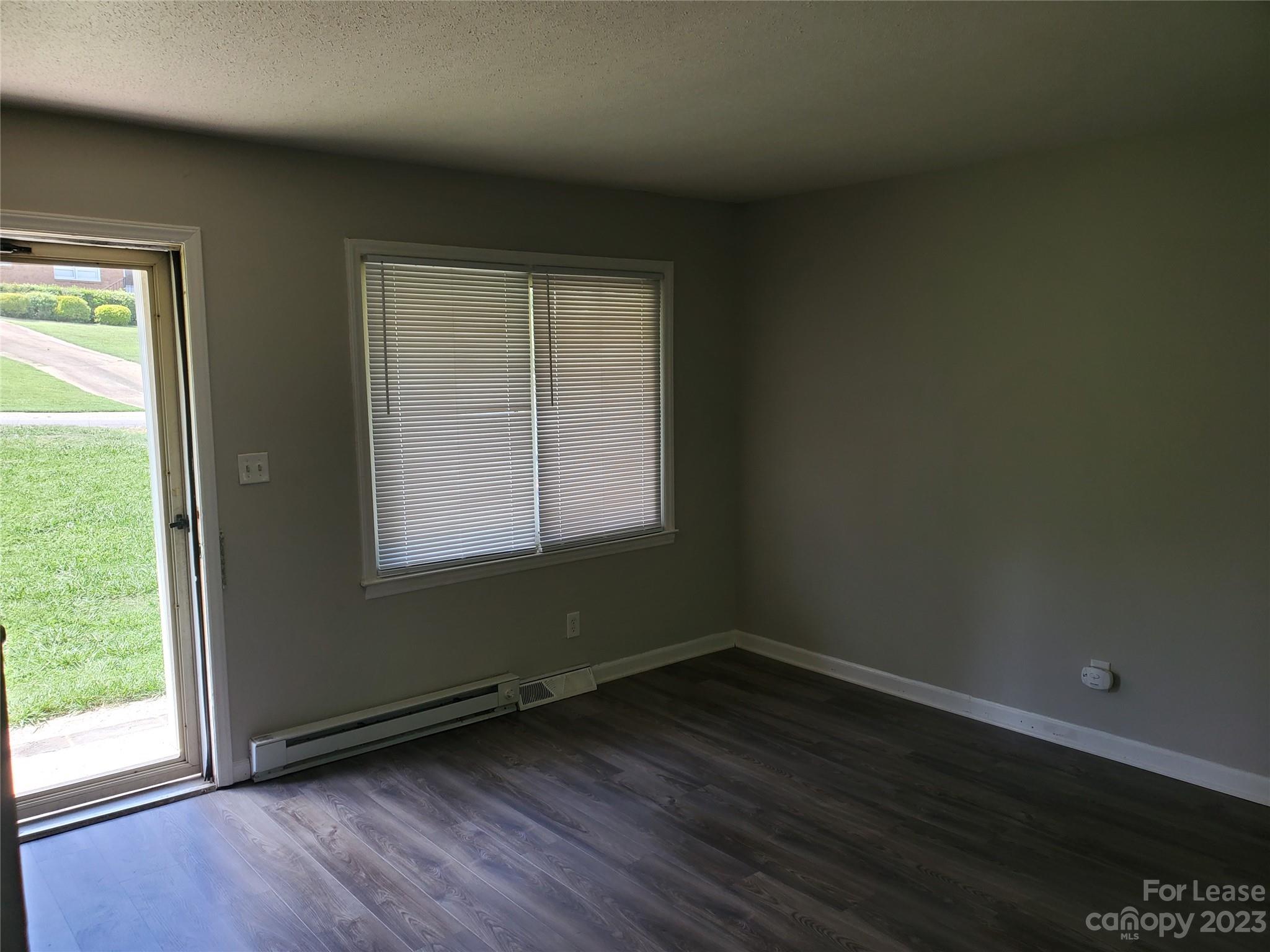 216 Lakeside Avenue Davidson, NC 28036 - Photo 5 of 6 an empty room with wooden floor and windows