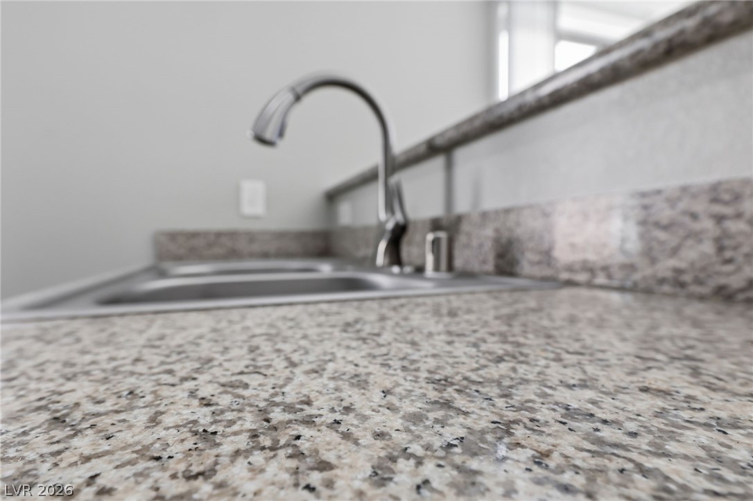 6312 Sandy Ridge Street, Unit 3102 North Las Vegas, NV 89081 - Photo 10 of 31 Premium speckled granite countertops and a stainless steel sink enhance this modern kitchen.