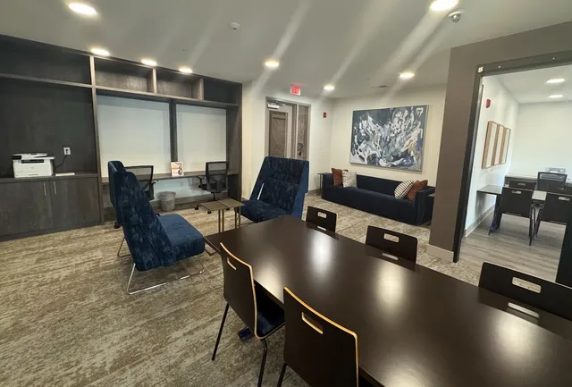 a living room with furniture a rug and white walls