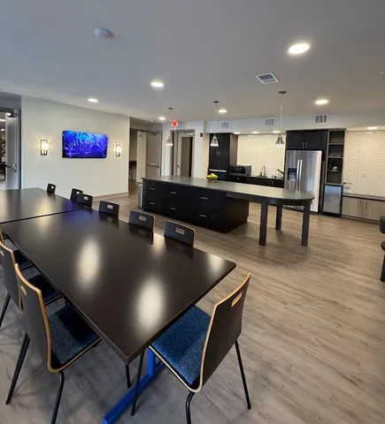 a living room with stainless steel appliances kitchen island granite countertop a sink and cabinets