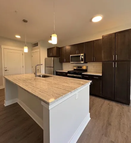a kitchen with a refrigerator sink and cabinets