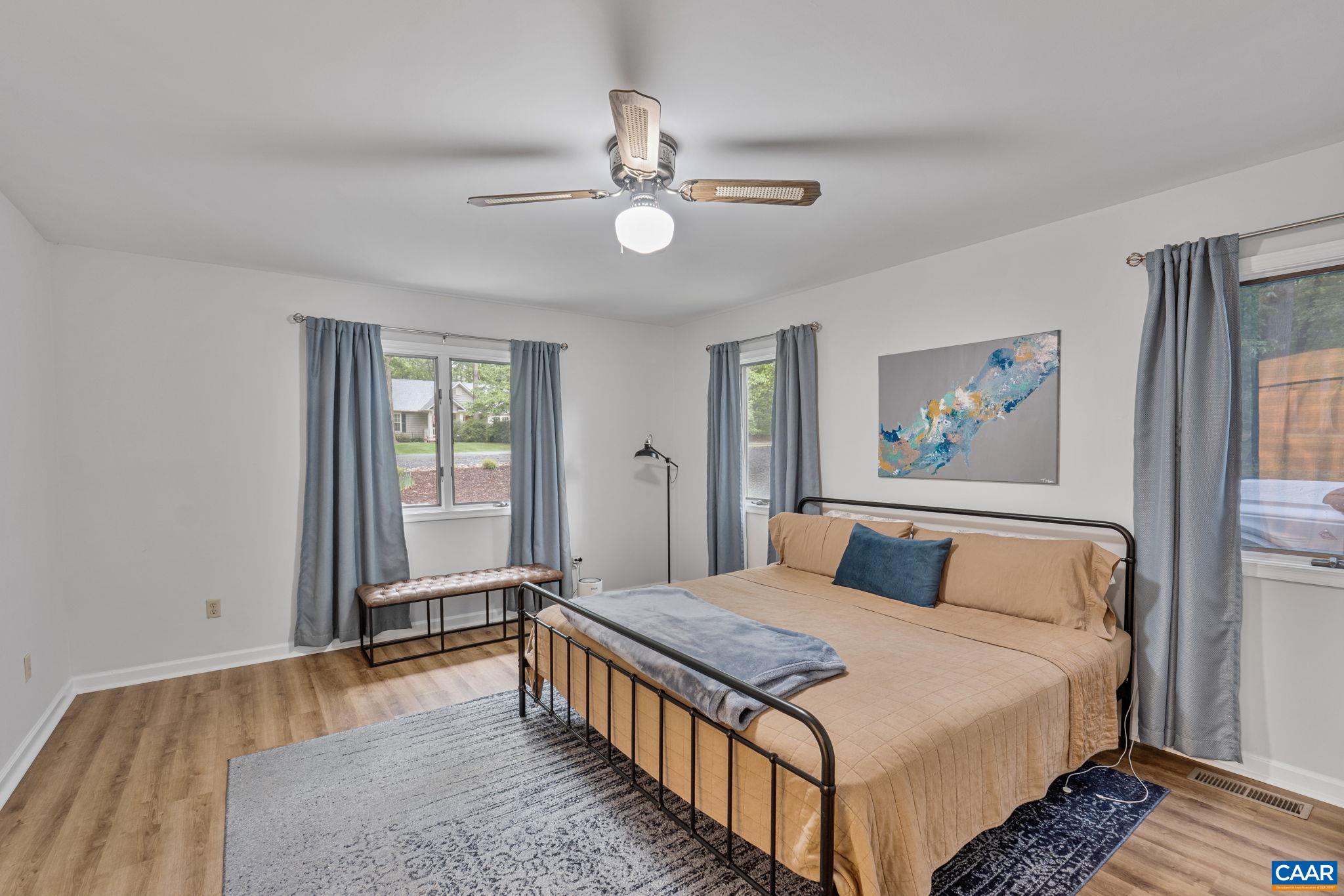 7 Sand Trap Terrace Palmyra, VA 22963 - Photo 18 of 27 a bedroom with a large bed and a chandelier