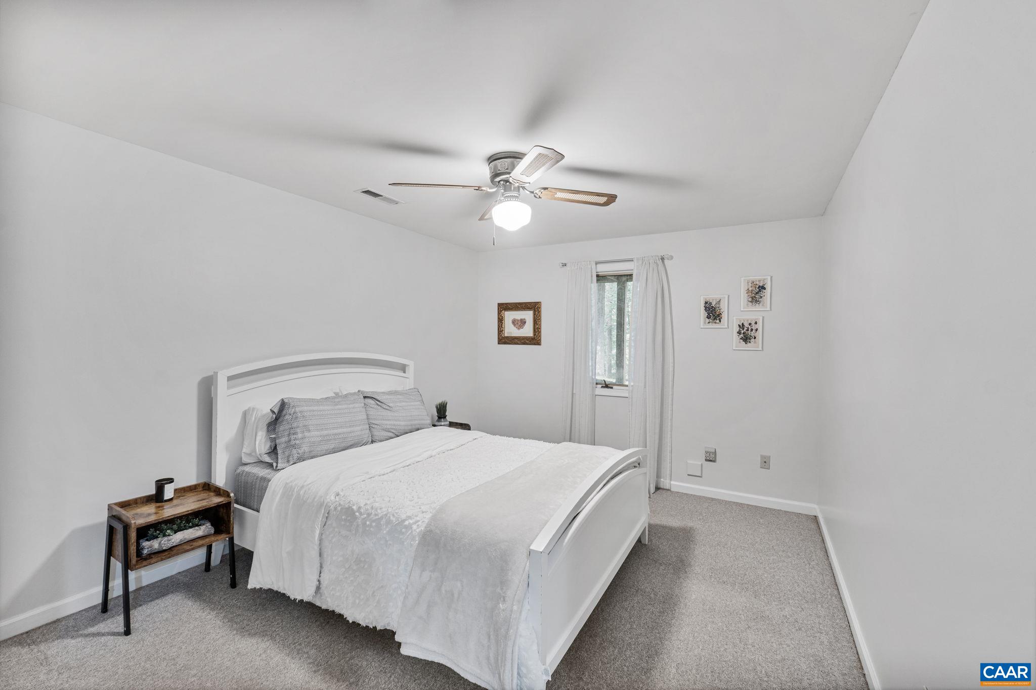 7 Sand Trap Terrace Palmyra, VA 22963 - Photo 25 of 27 a bedroom with a bed and a ceiling fan