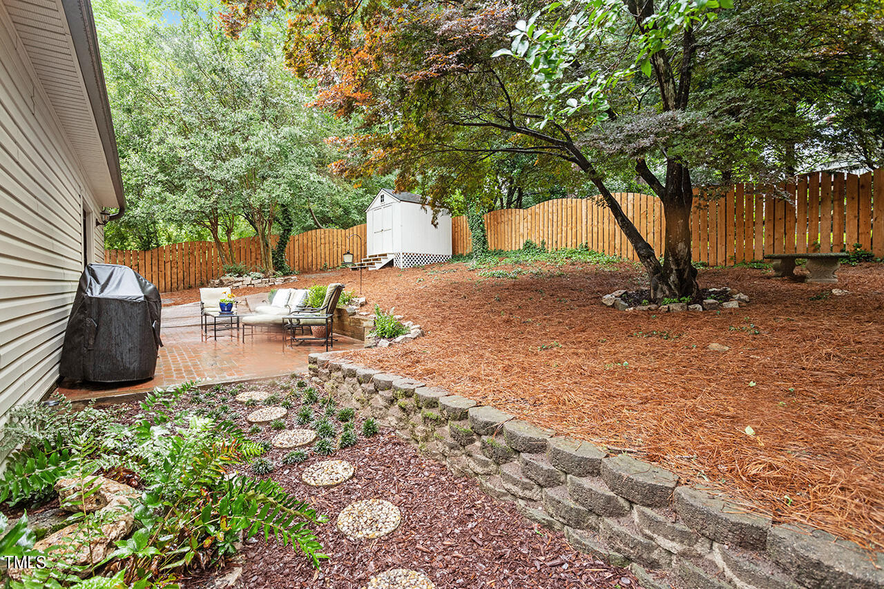 2718 Ashland Street Raleigh, NC 27608 - Photo 23 of 25 a backyard of a house with table and chairs under an umbrella