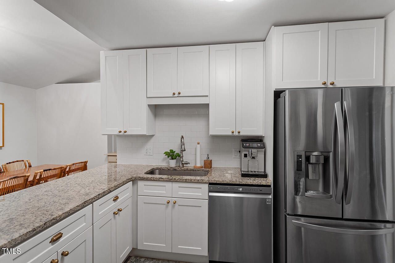2718 Ashland Street Raleigh, NC 27608 - Photo 8 of 25 a kitchen with stainless steel appliances white cabinets and a refrigerator