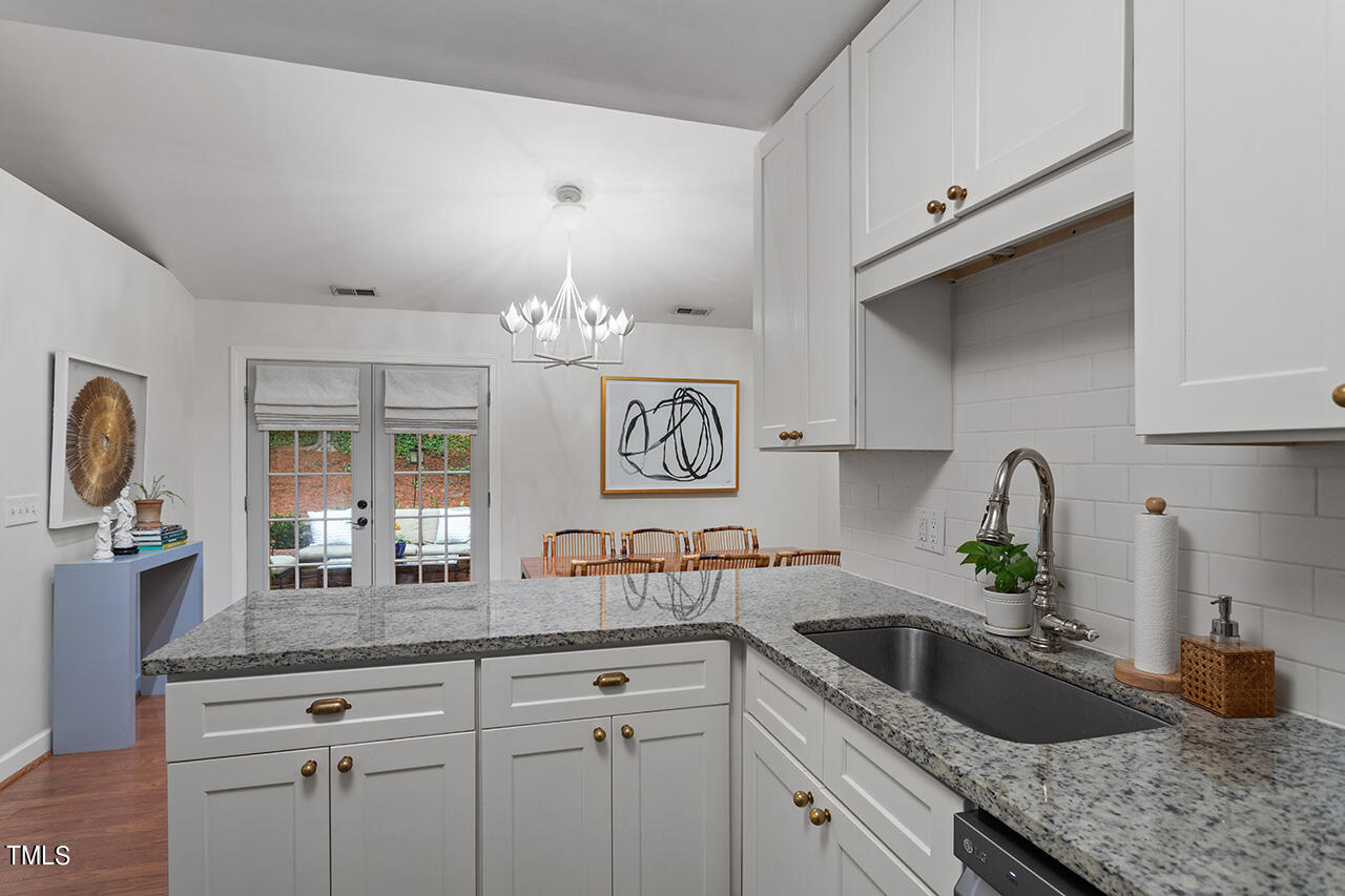 2718 Ashland Street Raleigh, NC 27608 - Photo 9 of 25 a kitchen with stainless steel appliances granite countertop a sink stove and cabinets
