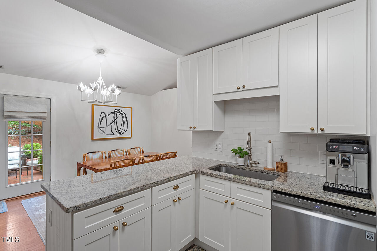 2718 Ashland Street Raleigh, NC 27608 - Photo 10 of 25 a kitchen with stainless steel appliances granite countertop a sink dishwasher and cabinets with wooden floor