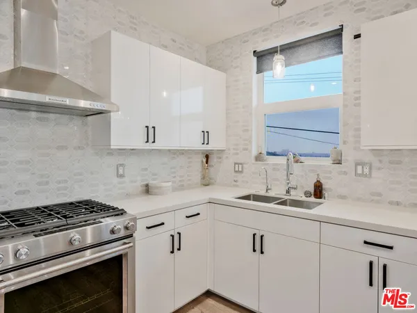 a kitchen with a sink stove and cabinets