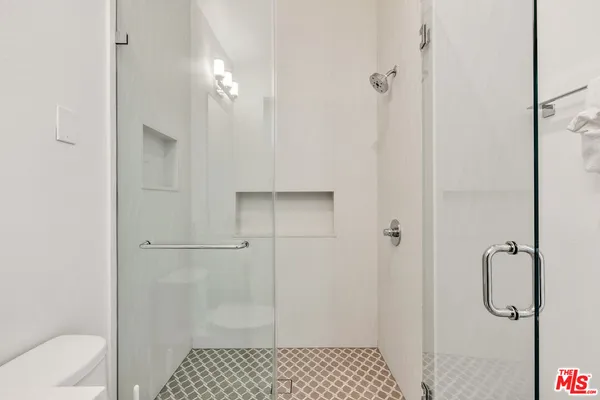 a bathroom with a toilet sink shower and mirror