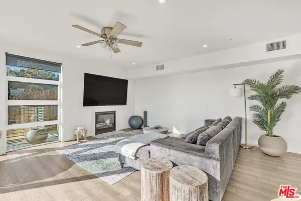 a kitchen with white cabinets white appliances sink and wooden floor