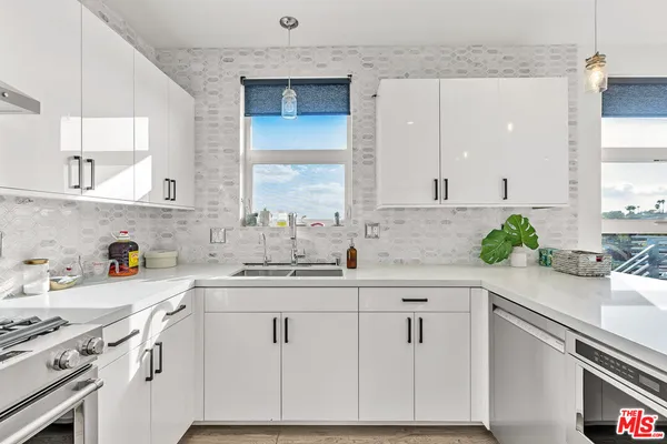 a kitchen with stainless steel appliances kitchen island a table and chair in it