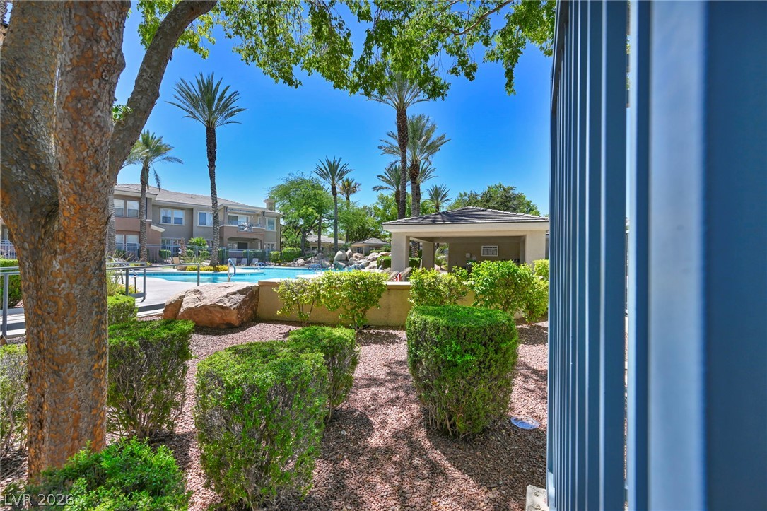 10730 Amber Ridge Drive, Unit 101 Las Vegas, NV 89144 - Photo 31 of 32 Lush landscaping surrounds the refreshing community pool and covered patio for optimal outdoor enjoyment.