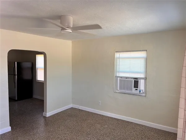 an empty room with windows and fan