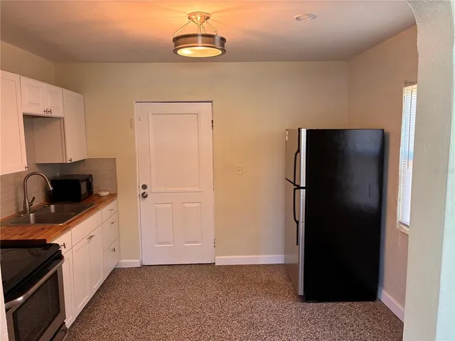 a view of a kitchen with a sink and a refrigerator