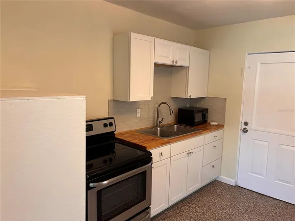 a kitchen with granite countertop white cabinets and white appliances