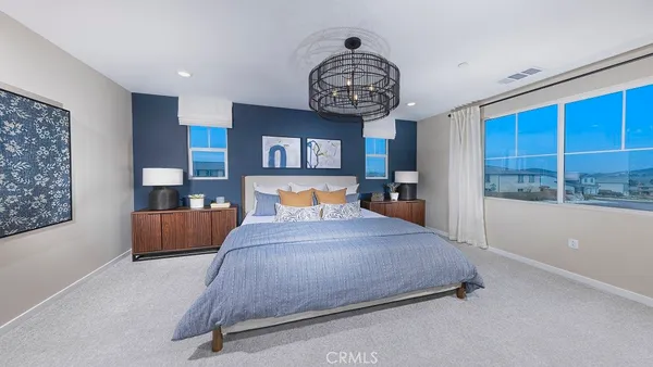 a spacious bedroom with a bed and a large window