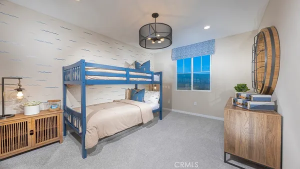 a bedroom with a bed a chandelier and dresser