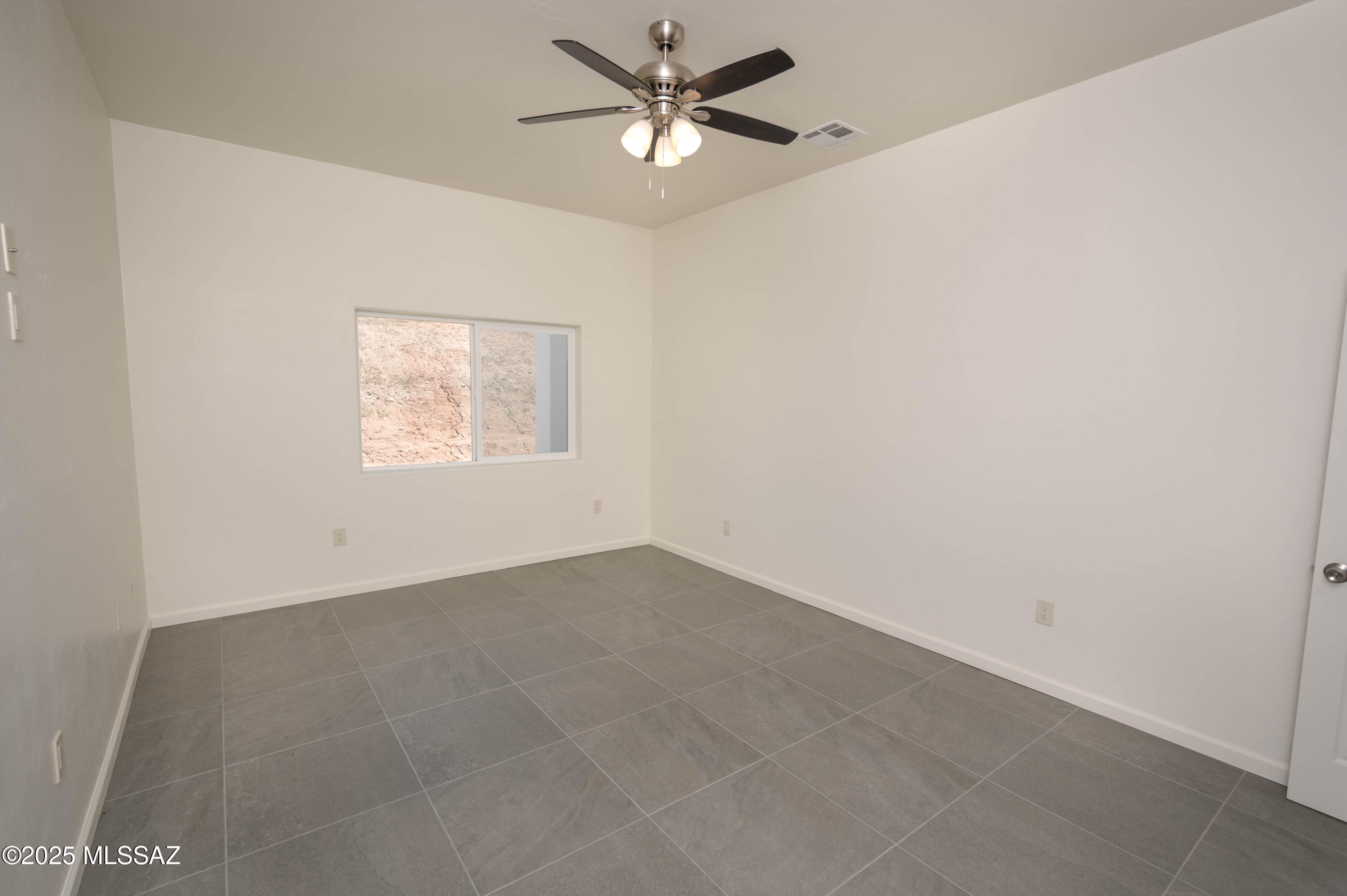 280 Donna Court Rio Rico, AZ 85648 - Photo 39 of 50 an empty room with a window and a fan