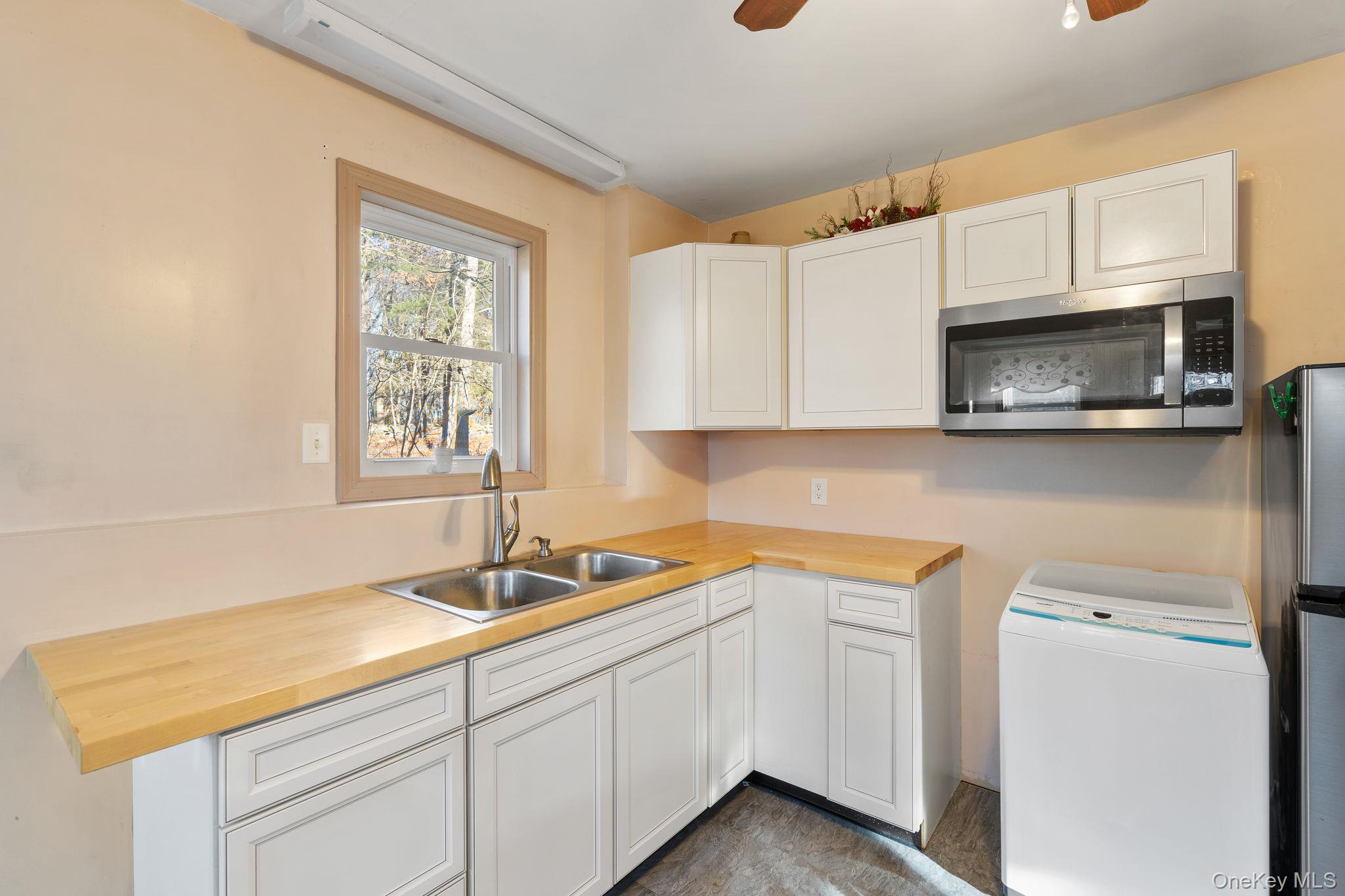 171 E Road Wallkill, NY 12589 - Photo 19 of 47 Kitchen with washer / dryer, appliances with stainless steel finishes, white cabinets, and a ceiling fan