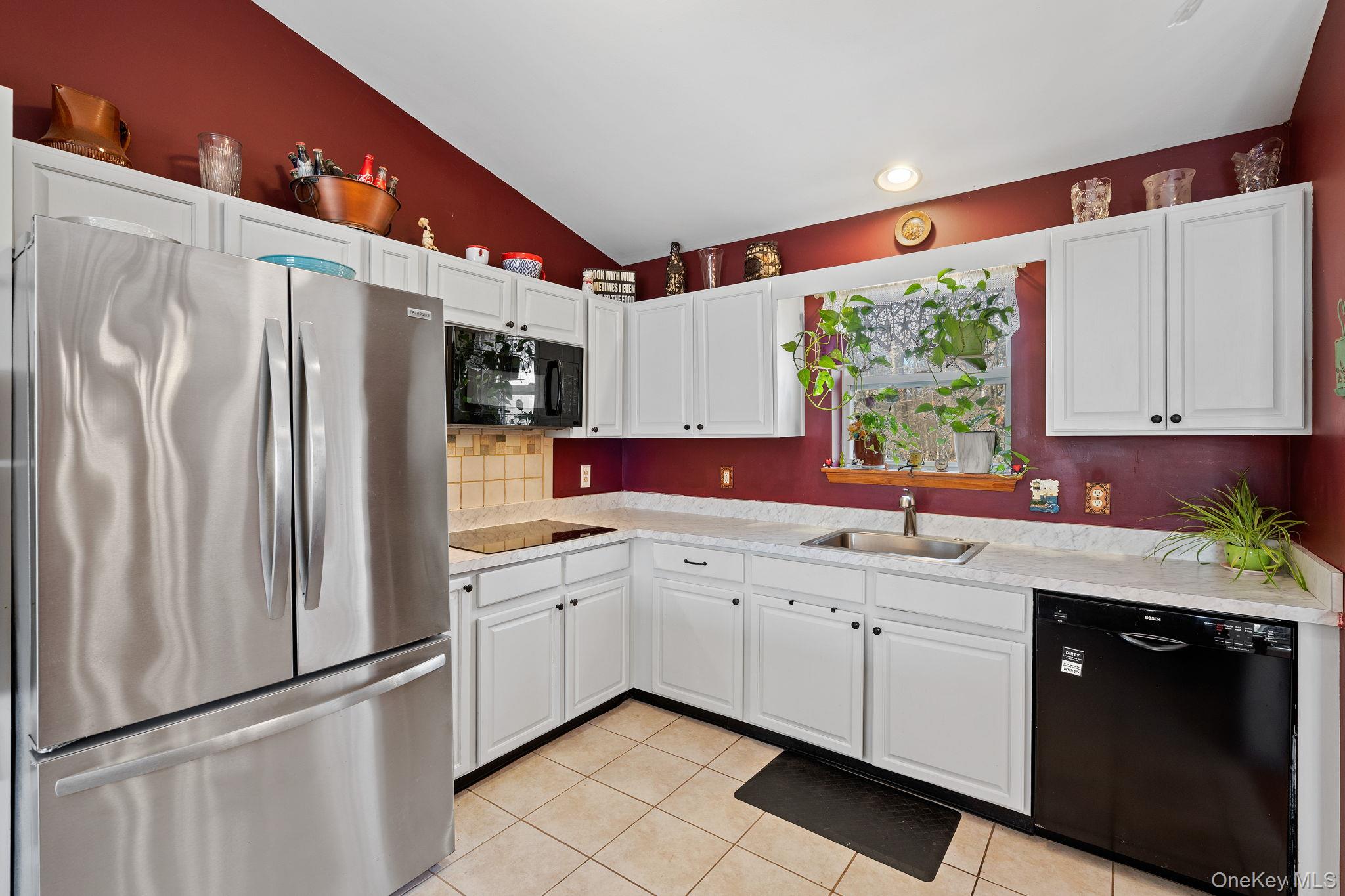 171 E Road Wallkill, NY 12589 - Photo 2 of 47 Kitchen featuring black appliances, light countertops, white cabinets, lofted ceiling, and light tile patterned floors
