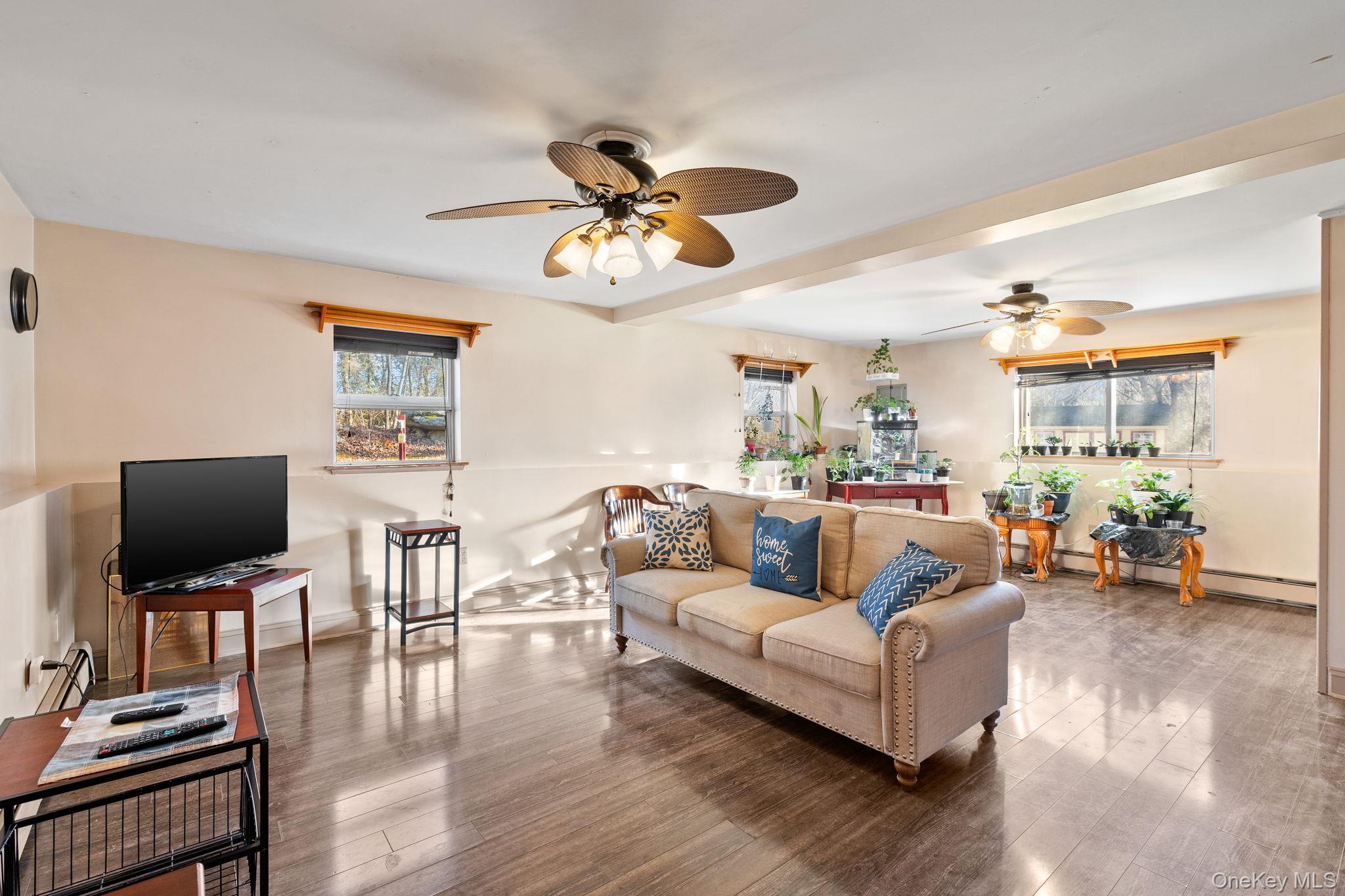 171 E Road Wallkill, NY 12589 - Photo 27 of 47 Living area featuring hardwood / wood-style floors, a baseboard heating unit, and a ceiling fan