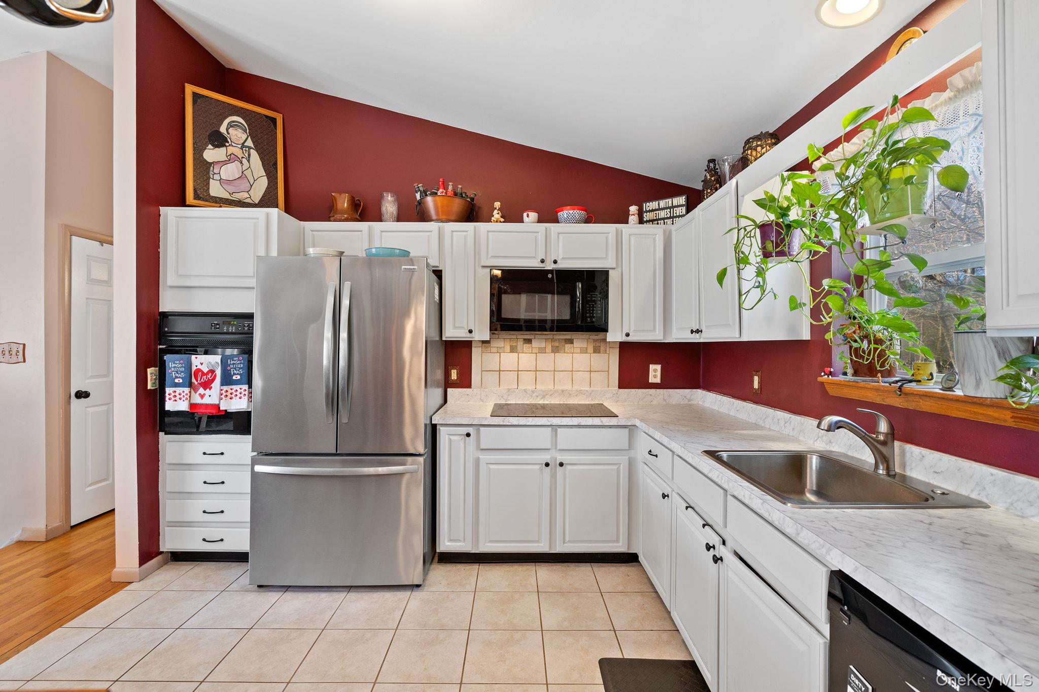 171 E Road Wallkill, NY 12589 - Photo 3 of 47 Kitchen with black appliances, lofted ceiling, white cabinetry, light countertops, and light tile patterned flooring