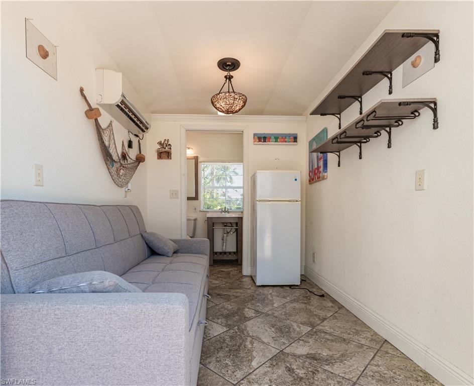 5216 Pineland Daisy Trail Fort Myers, FL 33905 - Photo 13 of 16 Kitchen featuring freestanding refrigerator, ornamental molding, open shelves, a wall unit AC, and hanging light fixtures
