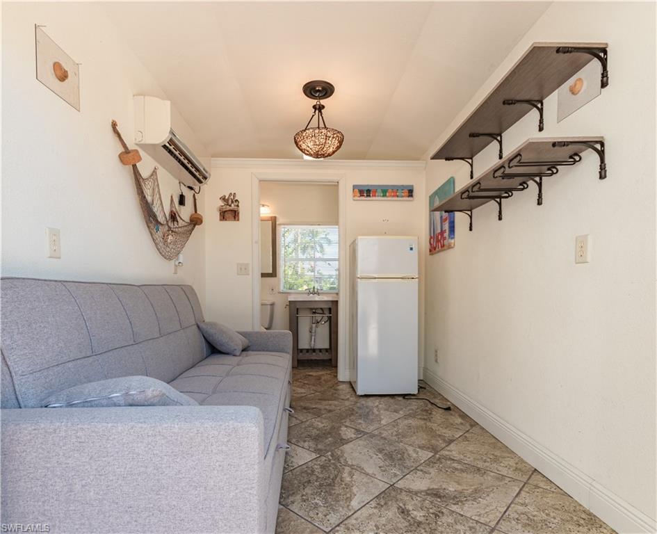 5216 Pineland Daisy Trail Fort Myers, FL 33905 - Photo 14 of 16 Kitchen with freestanding refrigerator, open shelves, crown molding, and a wall mounted air conditioner