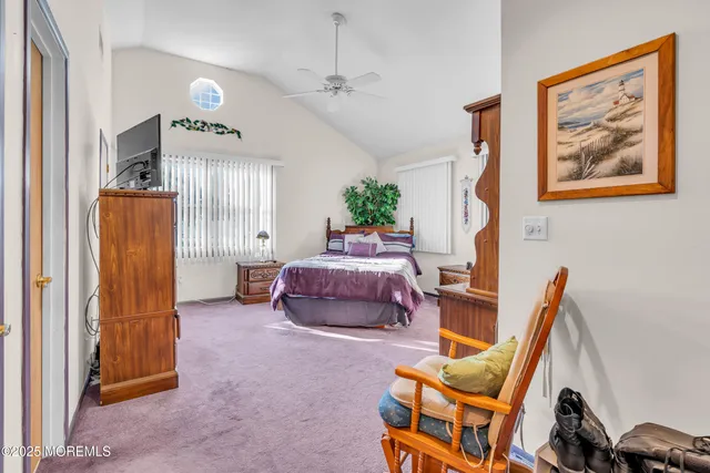 a bedroom with a bed and large windows