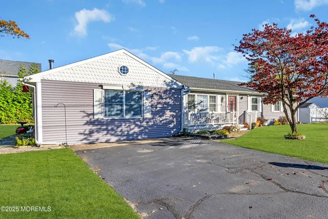 a front view of a house with a garden and trees