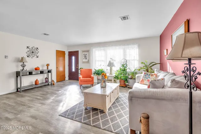 a living room with furniture a rug and white walls