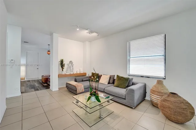 a living room with kitchen island furniture and a view of kitchen