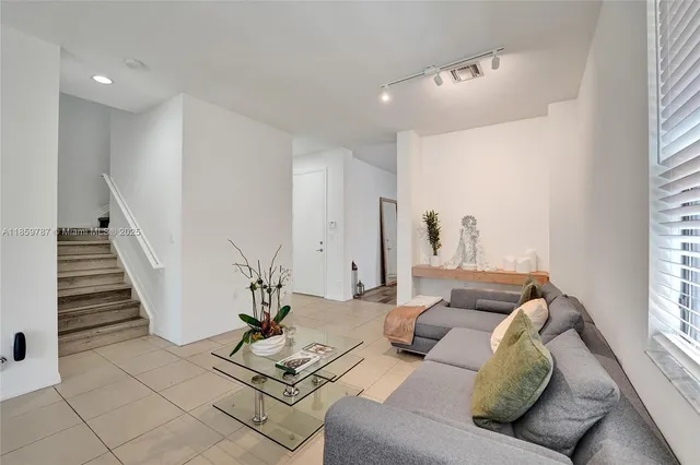 a living room with furniture a potted plant and a chandelier