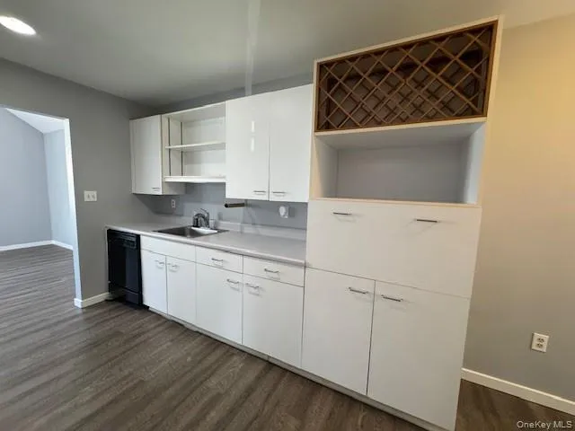 a kitchen with white cabinets a sink and dishwasher